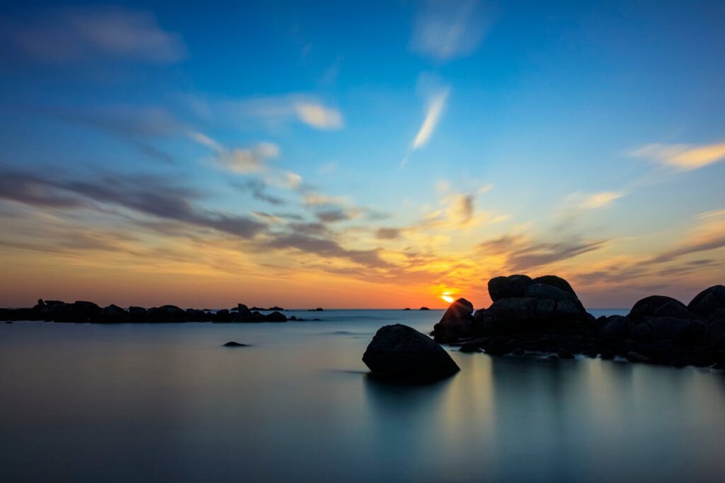 pexels photo 33405035 Captivating sunset over rocky shores in Bretagne, France with vibrant hues of the evening sky.